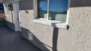 A building exterior with a window, a door, and a small overhang.