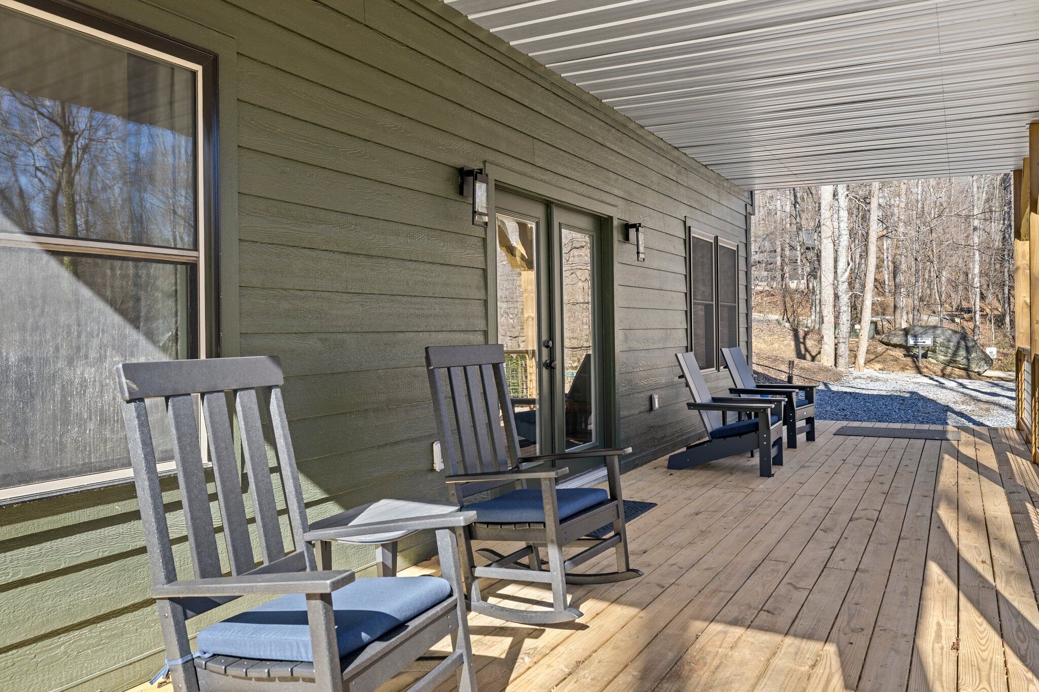 A covered deck with wooden flooring and outdoor seating.