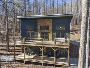 A two-story cabin with a balcony, wooden deck, and a stone fireplace. - NEW Mountain Modern Hideaway! - Walk to Disc Golf (Marion)