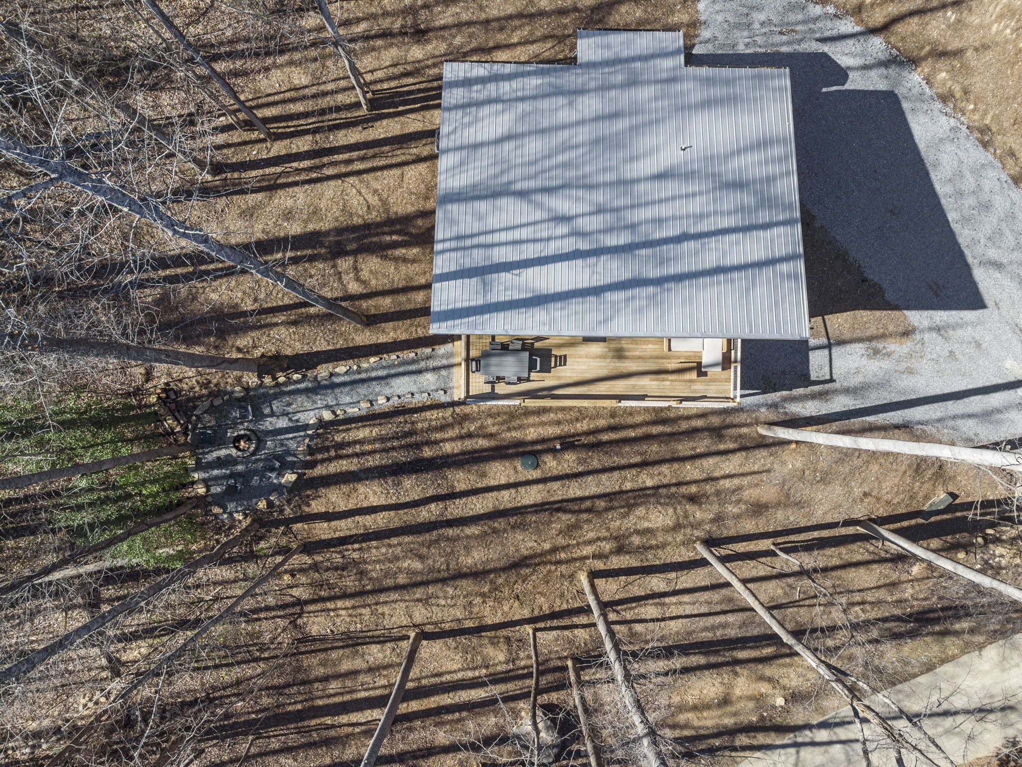 Luchtbeeld van een modern huis met een plat dak, omgeven door bebossing.