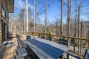 A wooden deck with a table and benches, overlooking a forested area. - NEW Mountain Modern Hideaway! - Walk to Disc Golf (Marion)