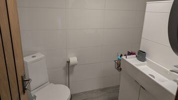 Un baño pequeño con inodoro, lavabo y espejo.