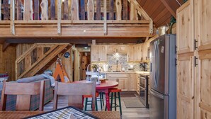 Un interno rustico con zona pranzo, angolo cottura e camera soppalcata.