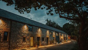 A stone building with multiple rooms, outdoor seating, and a paved driveway. - The Piggery - stylish barn conversion in the heart of the High Peak (Tideswell)