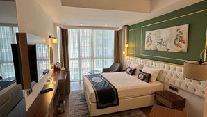 Een hotelkamer met een bed, nachtkastje, lamp en een schilderij aan de muur.