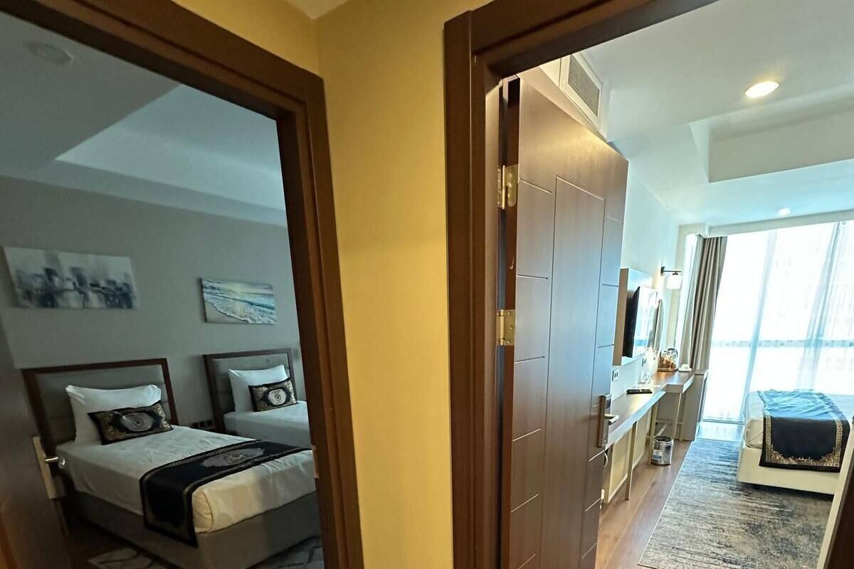 A hotel room with a bed, a desk, and a view of the sea.