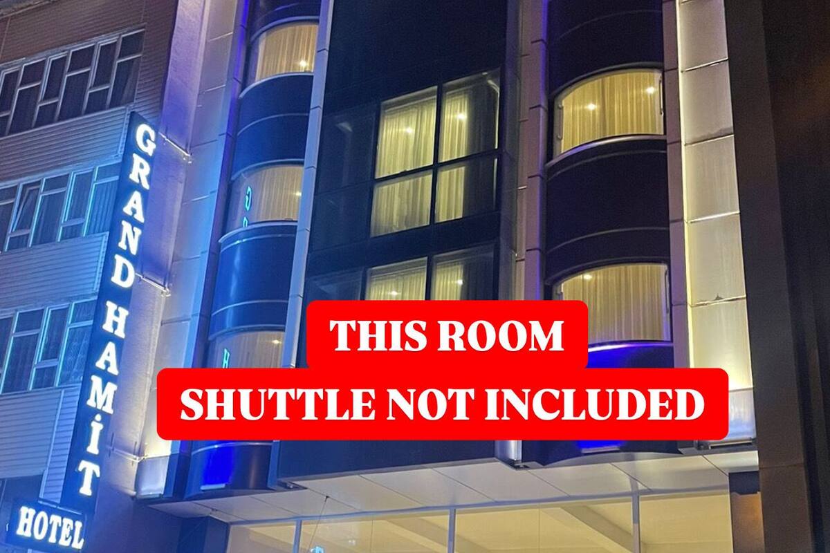 The Grand Hami Airport Hotel with a prominent sign indicating the shuttle service is not included.