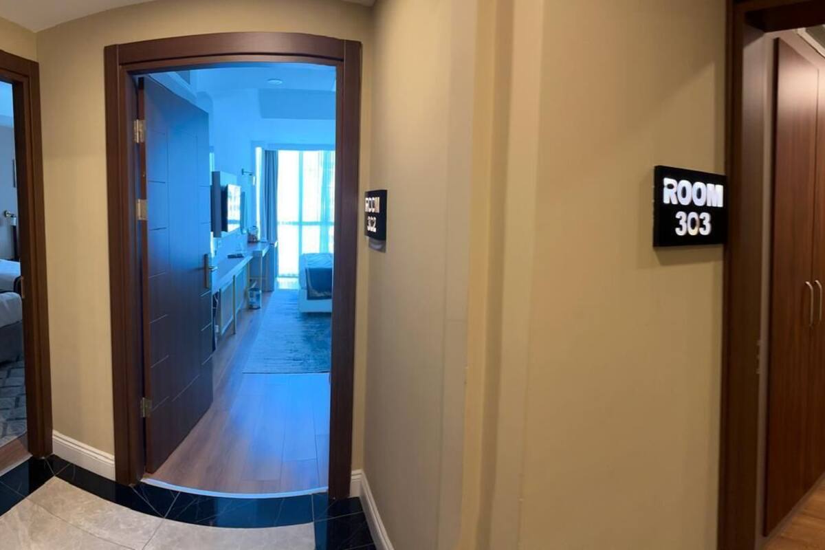 A hotel hallway with a sign indicating ROOM 303.