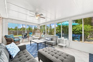 A sunroom with a ceiling fan, large windows, and outdoor seating. - Experience Navarre Beach just 7 mins away (Navarre)