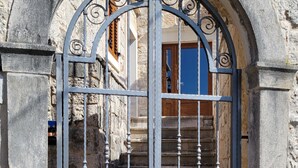 Un edificio in pietra con un cancello in metallo e un lucchetto a forma di cuore.