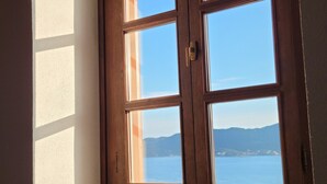 Una finestra con vista su un corpo d'acqua e montagne lontane.