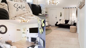 Una sala de estar acogedora con un sofá, una mesa de centro y un televisor. Hay una puerta que da a otra habitación y una mesita con una lámpara.