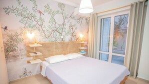 A bedroom with a bed, bedside tables, a wall mural, and a window with curtains. - 350m from museum of Acropolis a cozy & quit house (Αθήνα)