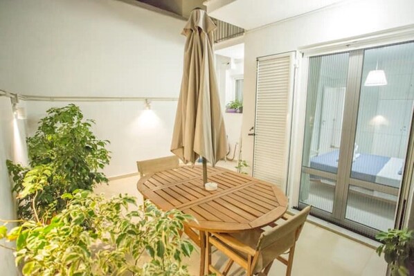 Enjoy dining or socializing on this balcony with a round table and chairs.