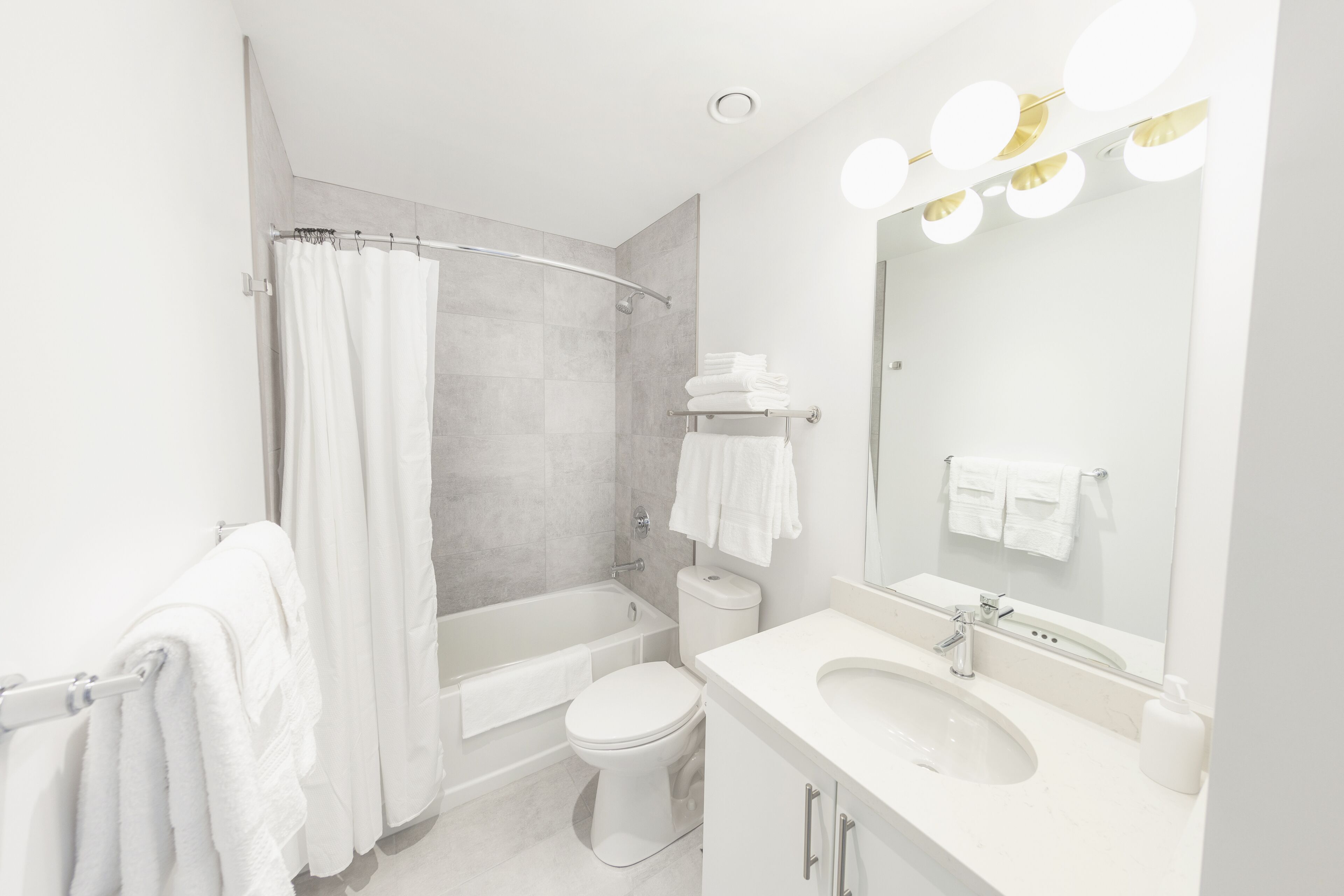 A modern bathroom with a bathtub, toilet, and sink.