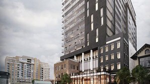 Ein modernes Hochhaus mit mehreren Stockwerken, großen Fenstern und einem markanten Eingangsbereich.