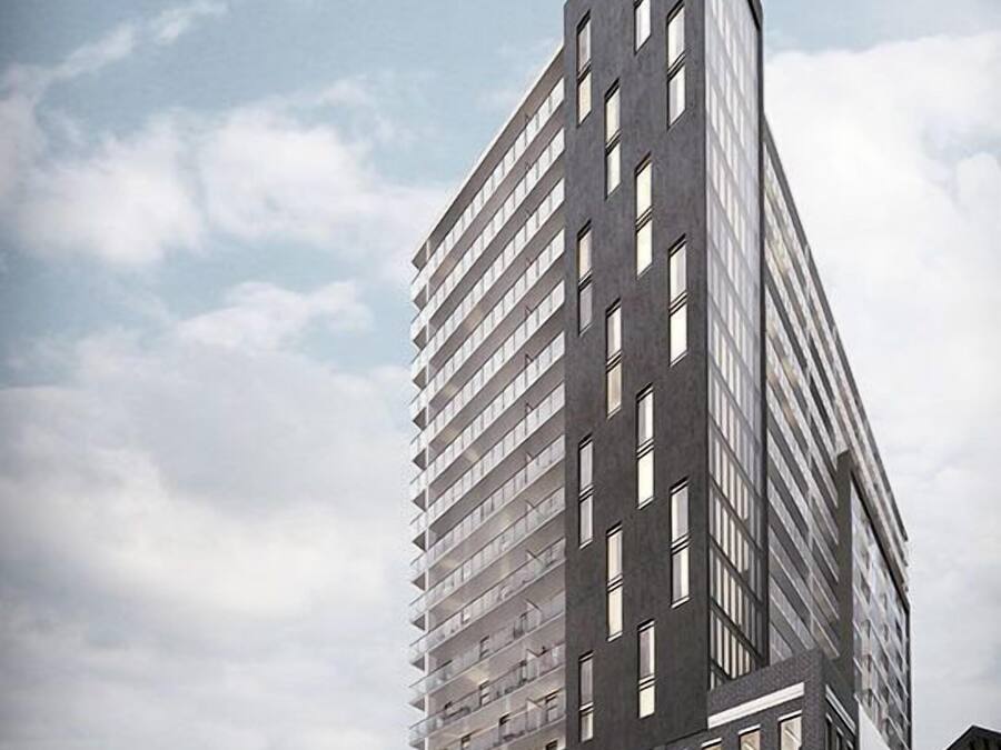 Un moderno edificio de gran altura con varios pisos, amplias ventanas y una entrada destacada.