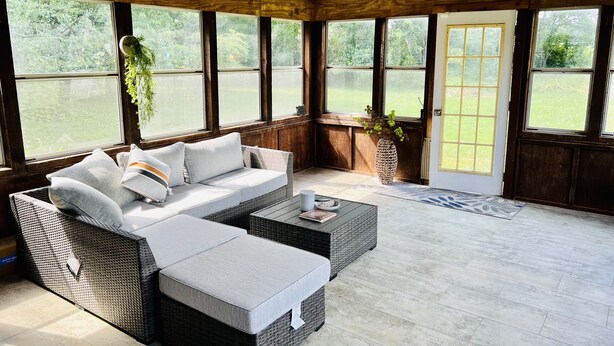 Ein gemütliches Zimmer mit einem Rattansofa, einem Couchtisch und einer Topfpflanze.