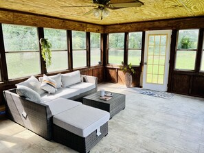 A cozy room with a wicker sofa, a coffee table, and a potted plant. - The Art of Seclusion (Yellow Springs)