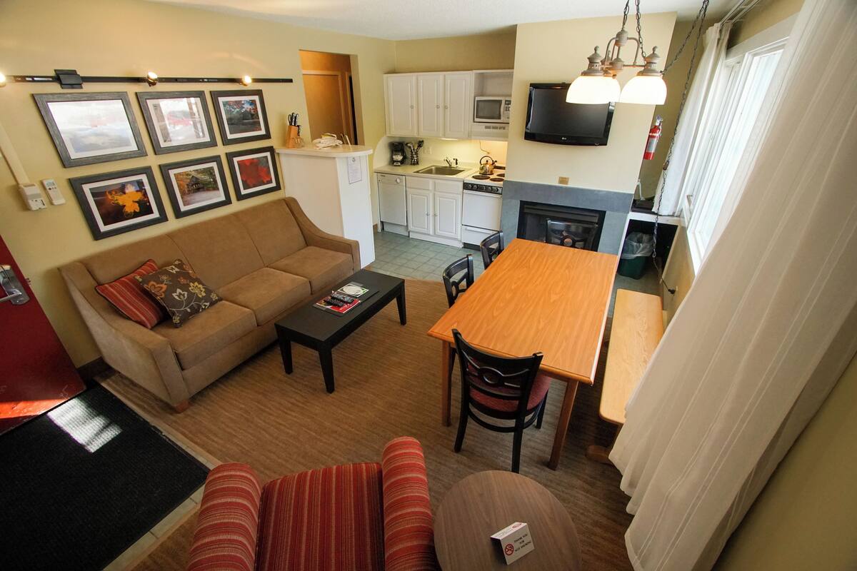 A compact living space with a sofa, a dining table, and a kitchen area.