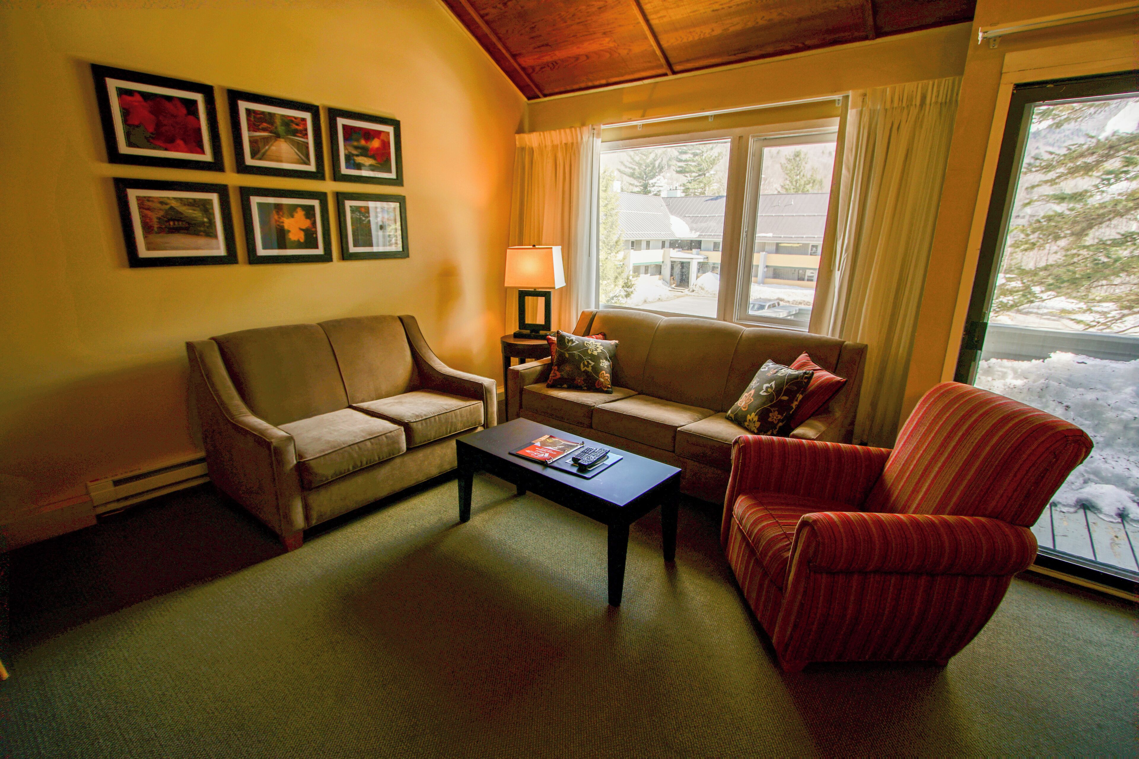 A living room with a sofa, armchair, coffee table, and a lamp.