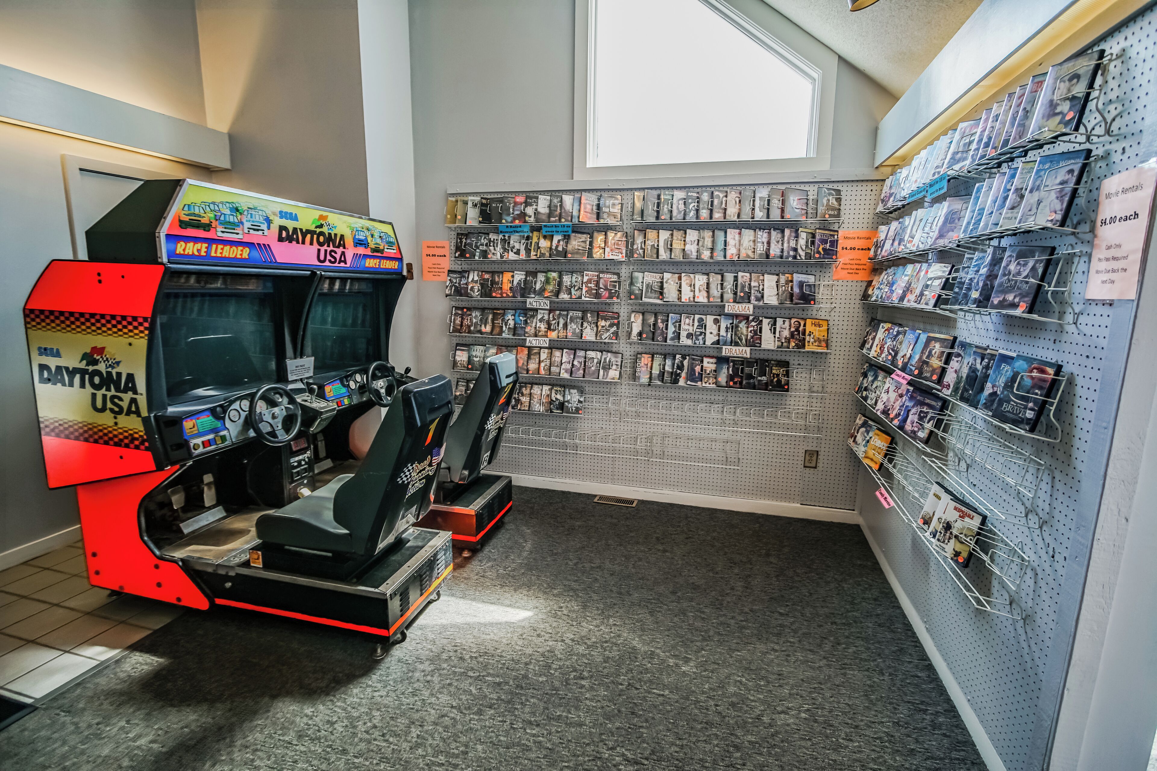 En leje-arkade med NASCAR-tema, inklusive en racersimulator og en væg med udlejning af videospil.