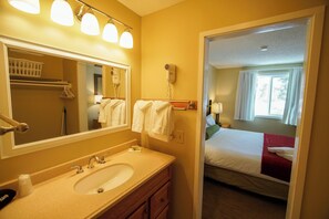 A hotel bathroom with a sink, mirror, and towel rack. - The Village of Loon Mountain Fixed Rooms (Lincoln)