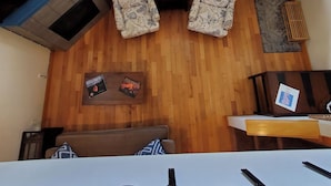 A room with two patterned armchairs, a wooden coffee table with books, a sofa, and a TV on a stand. - Judkins Park Light Rail Townhouse Haven (Seattle)