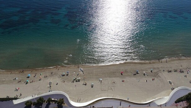 An aerial view of a beach with a curved walkway leading to the water. - Apartamentos Beni Beach (Benidorm)