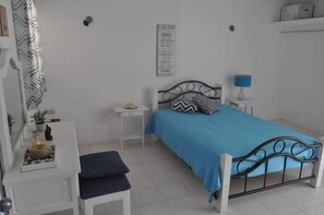 Cozy retreat with a single bed, nightstand, and desk, set against a clean, minimalist backdrop.