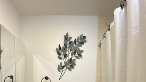 A bathroom with a sink, mirror, towel rack, and shower curtain. - Comfy, private one Bedroom Apartment with full kitchen, living room, full bath. (Ridge)