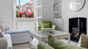 A modern living room with a sofa, armchair, and a glass coffee table. - Bay View Luxury Stays - Iris Boutique Harbour Cottage, walking distance to Beach (Weymouth)