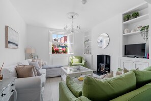 Smart TV, lareira, livros, aparelho de som