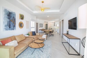 Un salon moderne comprenant un canapé, une table basse et un coin repas avec une table et des chaises.