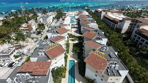 A resort with multiple buildings, a central pool, and a beach view. - Luxury 3BR beachfront Condo in Punta Cana (Punta Cana)