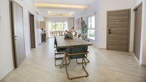 A spacious dining area with a long table, chairs, and a ceiling fan. - Luxury 3BR Beachfront Condo in Punta Cana (Punta Cana)