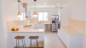 A modern kitchen with a central island, stainless steel appliances, and pendant lighting. - Luxury 3BR Beachfront Condo in Punta Cana (Punta Cana)