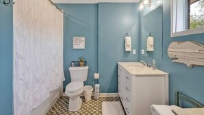Ein Badezimmer mit Toilette, Waschbecken und Duschvorhang.