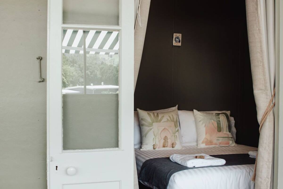 Ein Schlafzimmer mit Bett, Kissen und einem Fenster.