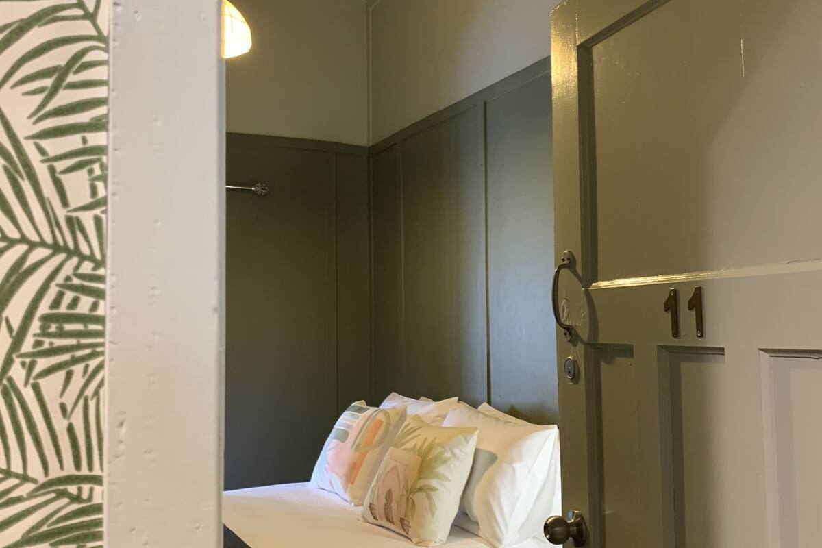 Ein Schlafzimmer mit einem Bett, einem Deckenventilator und einer Tür mit der Nummer 11.