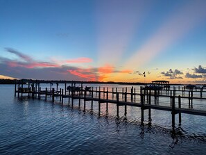 A waterfront dock with boats and a pier extending into calm water. - The Dolphin House! Heated Pool home. Unlimited well mannered Pets Welcome (Ormond Beach)