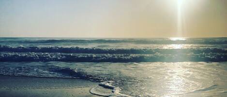 A beach with waves and sunlight.