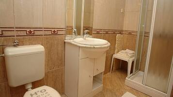 A bathroom with a toilet, sink, and shower.