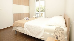 A bedroom with a bed, a wardrobe, a window, and a view of the outdoors. - Pansion Jurko - Double Room with Balcony and Sea View (Pag)