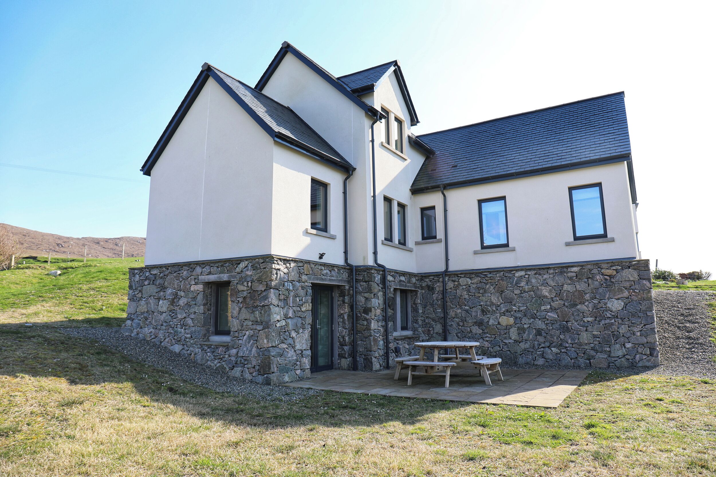 A two-story house with a stone foundation and a modern design.