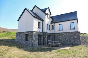 A two-story house with a stone foundation and a modern design.