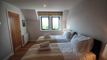 Quarto com duas camas, janela com vista, radiador e porta.
