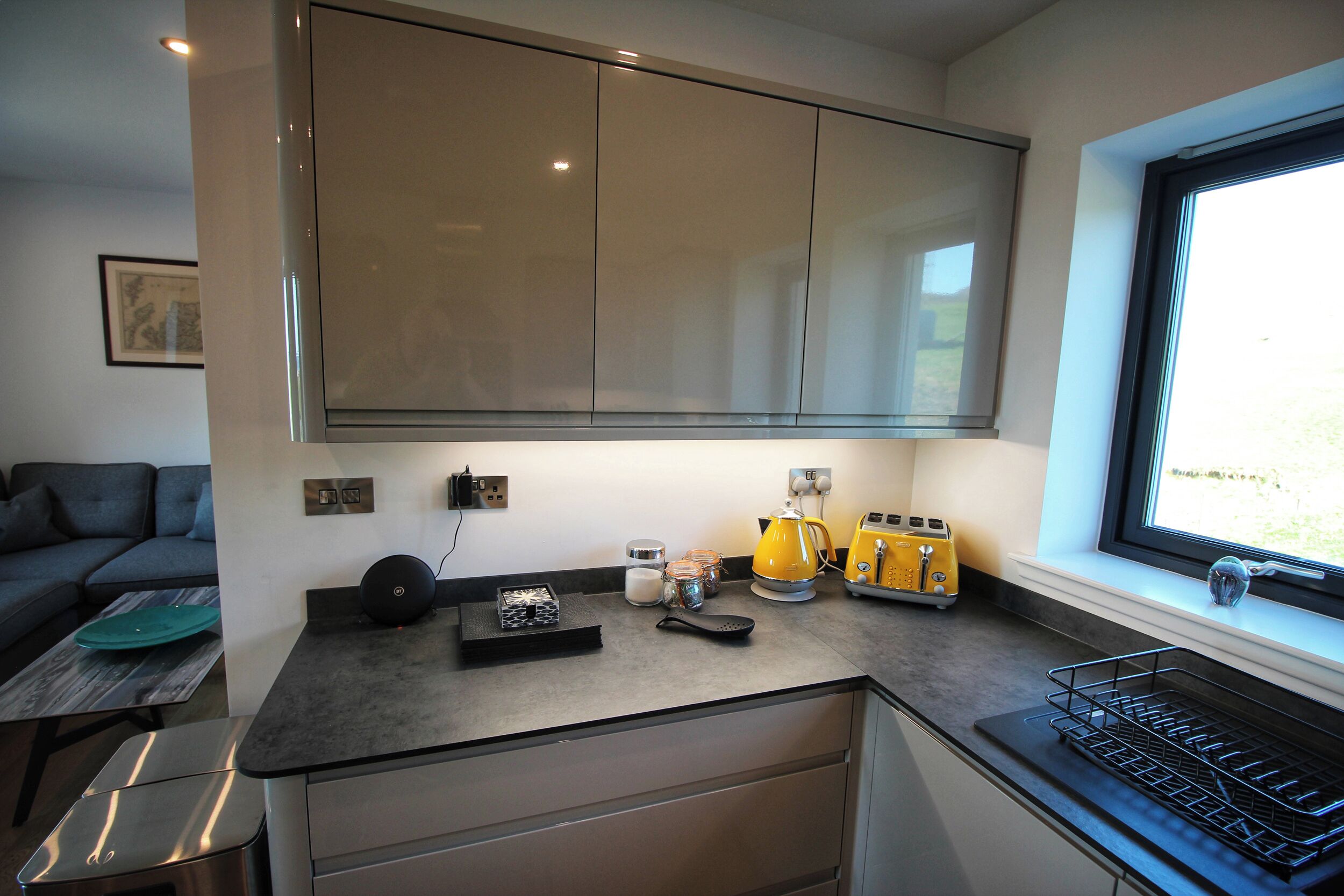 A modern kitchen with a built-in oven, a coffee maker, and a toaster.