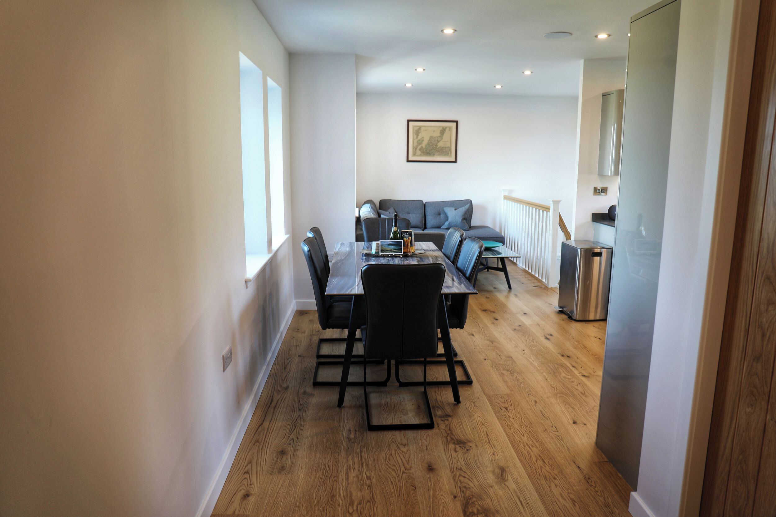 Un espacio habitable compacto con comedor, un conjunto de sofás y una kitchenette.