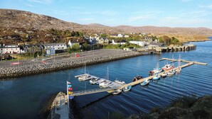 Un puerto con barcos amarrados, un muelle y edificios al fondo.